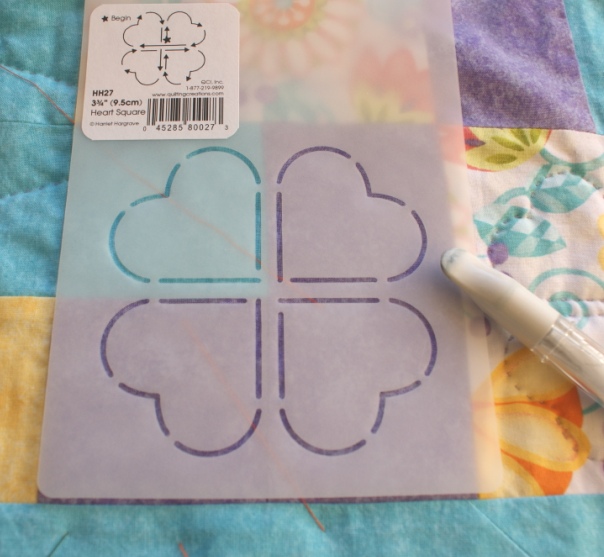 Ready to mark a section of a quilt top using a stencil.