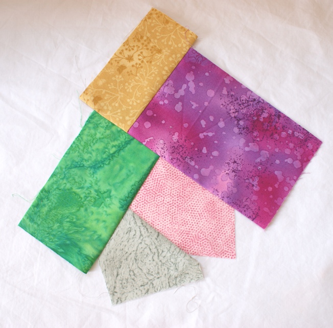 The multi-fabric piece stitched, flipped and pressed into place. Continue moving around the centre piece until you have fabric covering the base fabric beyond the size of the finished block you desire. Trim to the required size - allowing your quarter inch seam allowance all round.