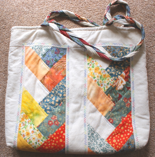 Here's the bag made using the friendship braid block.  I carried the braid theme into the handles - plaiting three tubes of fabric and running a line of stitching through them.  In hindsight I should have put a layer of thin wadding in each 'tube' just to give the handles a little more 'substance'.