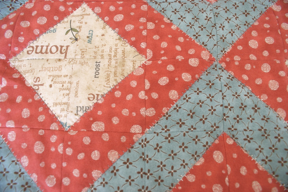 I decided to quilt around the diamond pattern created by the HSTs using one of my sewing machines top-stitches rather than quilting in the ditch. 