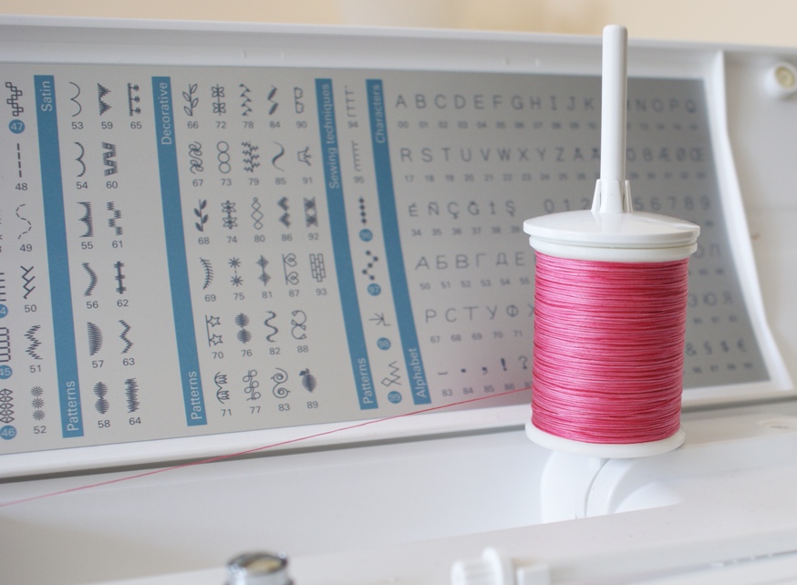 Thread wound onto a reel in a linear fashion is designed to feed off sideways and therefore should be put on the vertical spool of a machine.