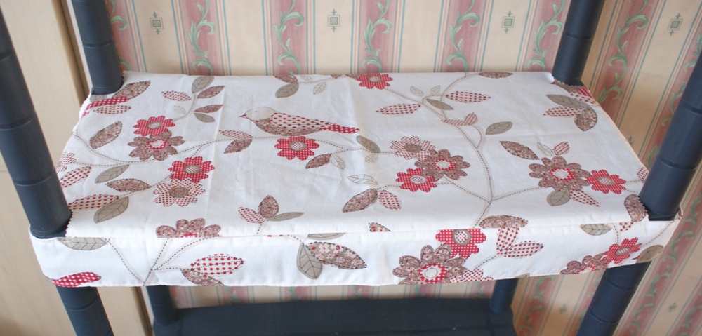 I have two black plastic shelf units that look very utilitarian. I had a look in our local ASDA and found this lovely bedding to cut up and make into shelf covers :-)