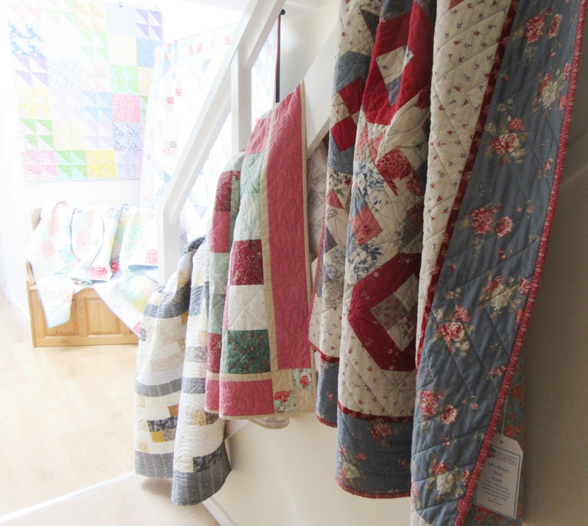 Quilts on the banisters by Allison Reid